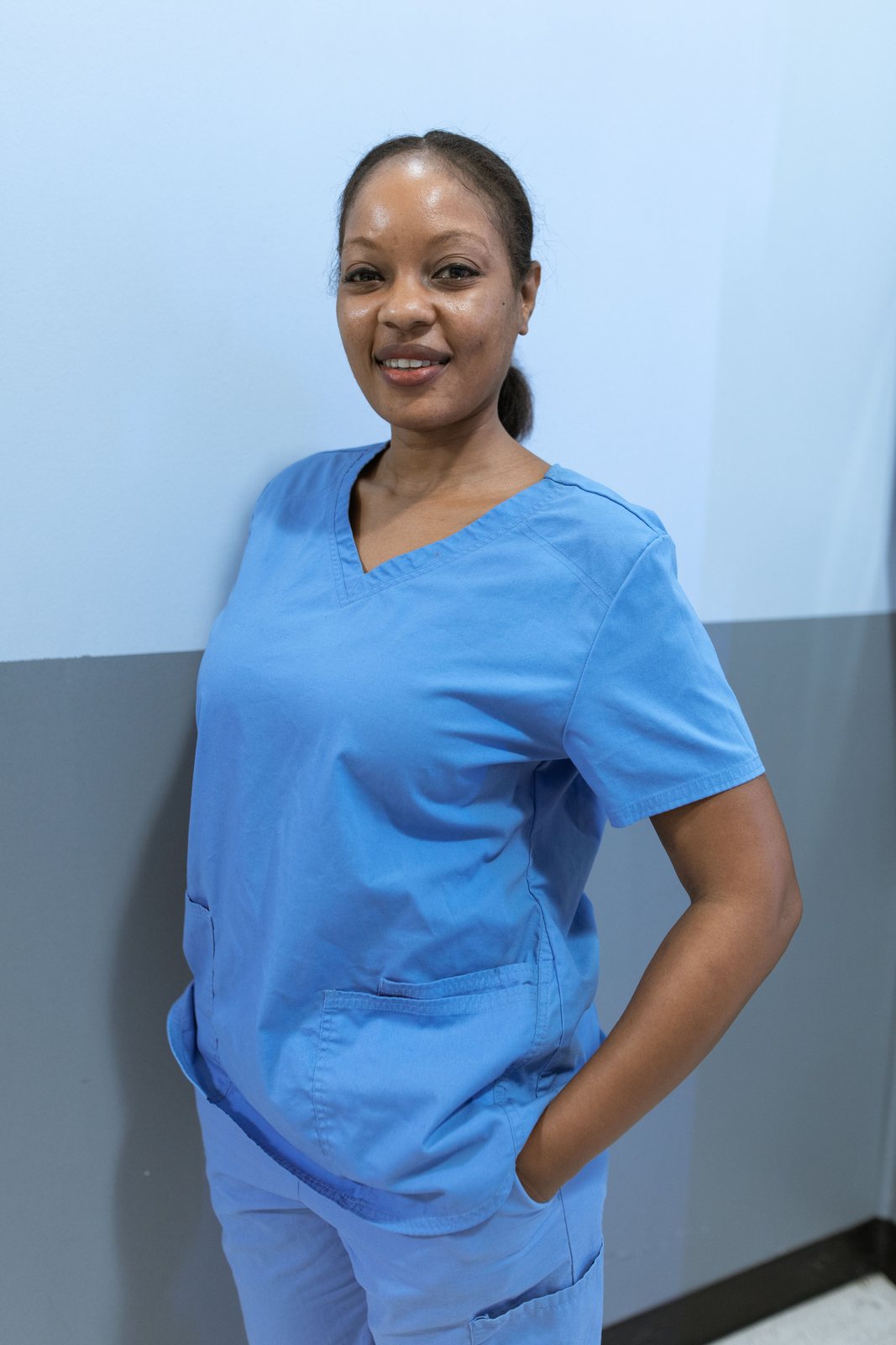 A smiling Black healthcare professional wearing scrubs